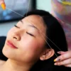 Beautician threading a woman's eyebrows in a salon
