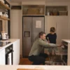 Father and son loading a dishwasher in the kitchen