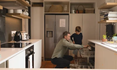 Father and son loading a dishwasher in the kitchen