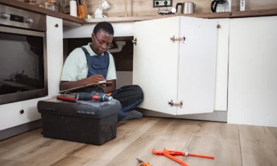 Plumber checking the pipes and stop tap under a kitchen sink