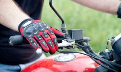 Rider wearing protective motorcycle gloves with knuckle armour on the handlebar