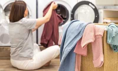 Woman loading laundry into a washing machine in a utility room