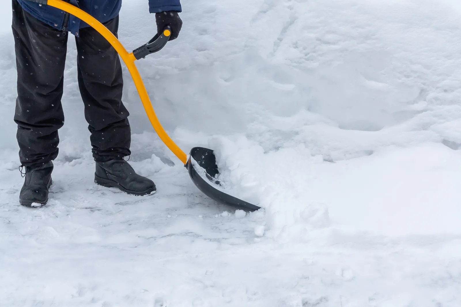 Person clearing heavy snow with a shovel