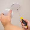 Smoke alarm being fitted to a ceiling at home