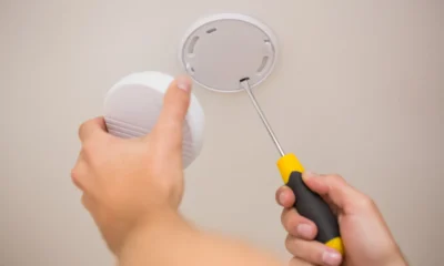 Smoke alarm being fitted to a ceiling at home