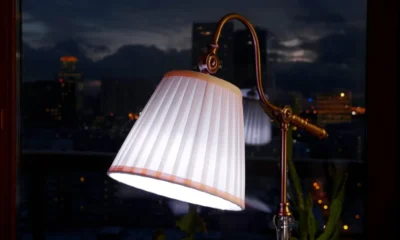 Table lamp with a pleated shade glowing by a window on a dark evening